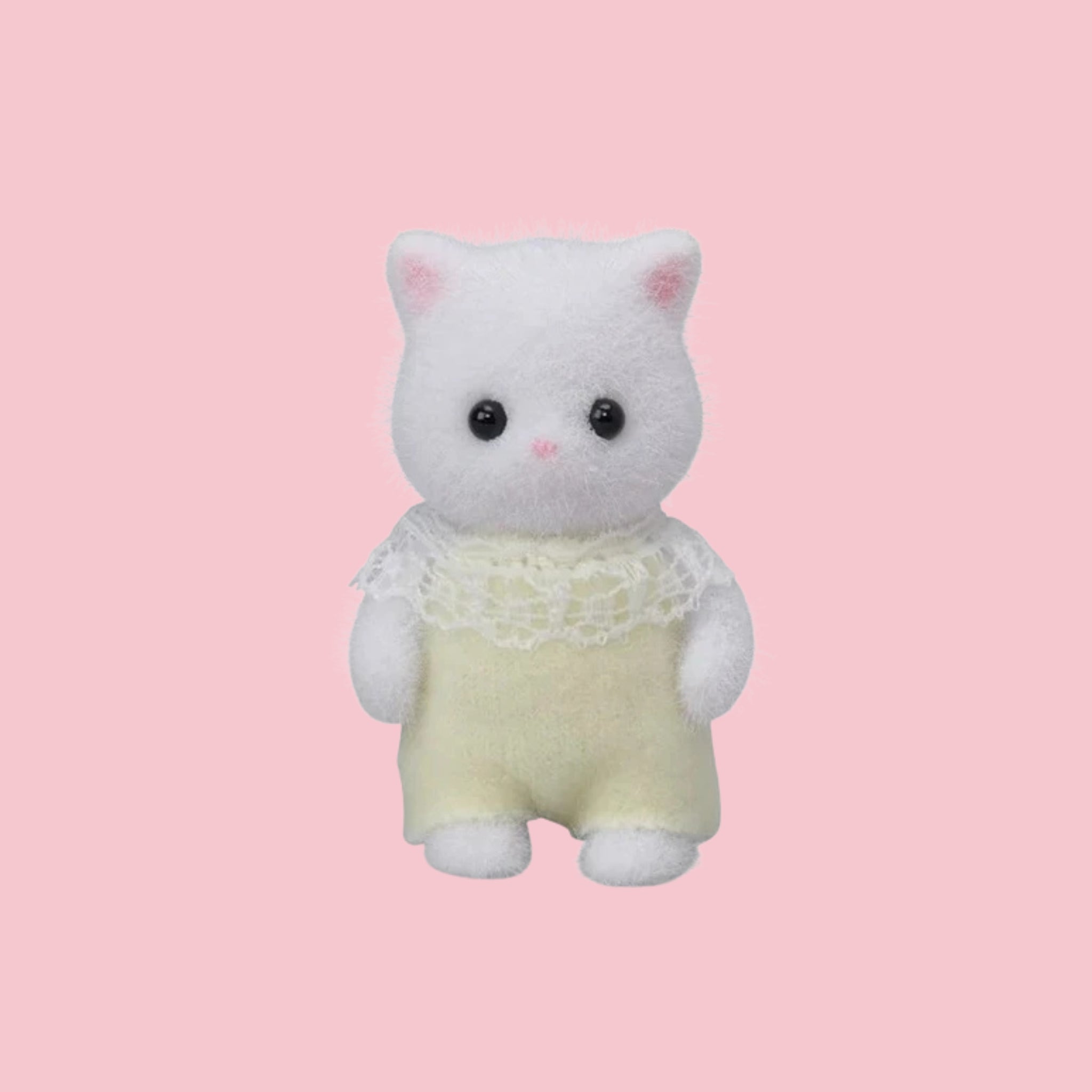 Sylvanian Families persian cat baby figure in green outfit, shown against a pink background.