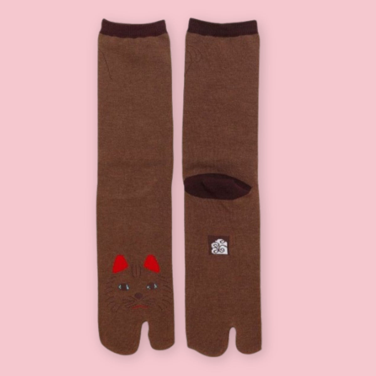 Brown Japanese tabi socks with split toes and embroidered cat face on a pink background