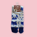 Blue and gray Japanese tabi socks with assorted dog face pattern and traditional split-toe design, shown in packaging.