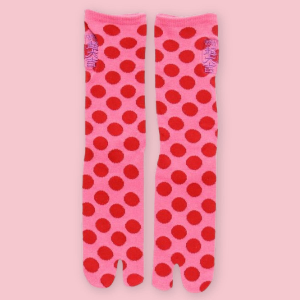 Pink Japanese tabi socks with red polka dots and traditional split-toe design.