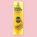 TonyMoly Banana Hand Milk shown in its banana-shaped retail packaging with English and Korean text, on a pink background.