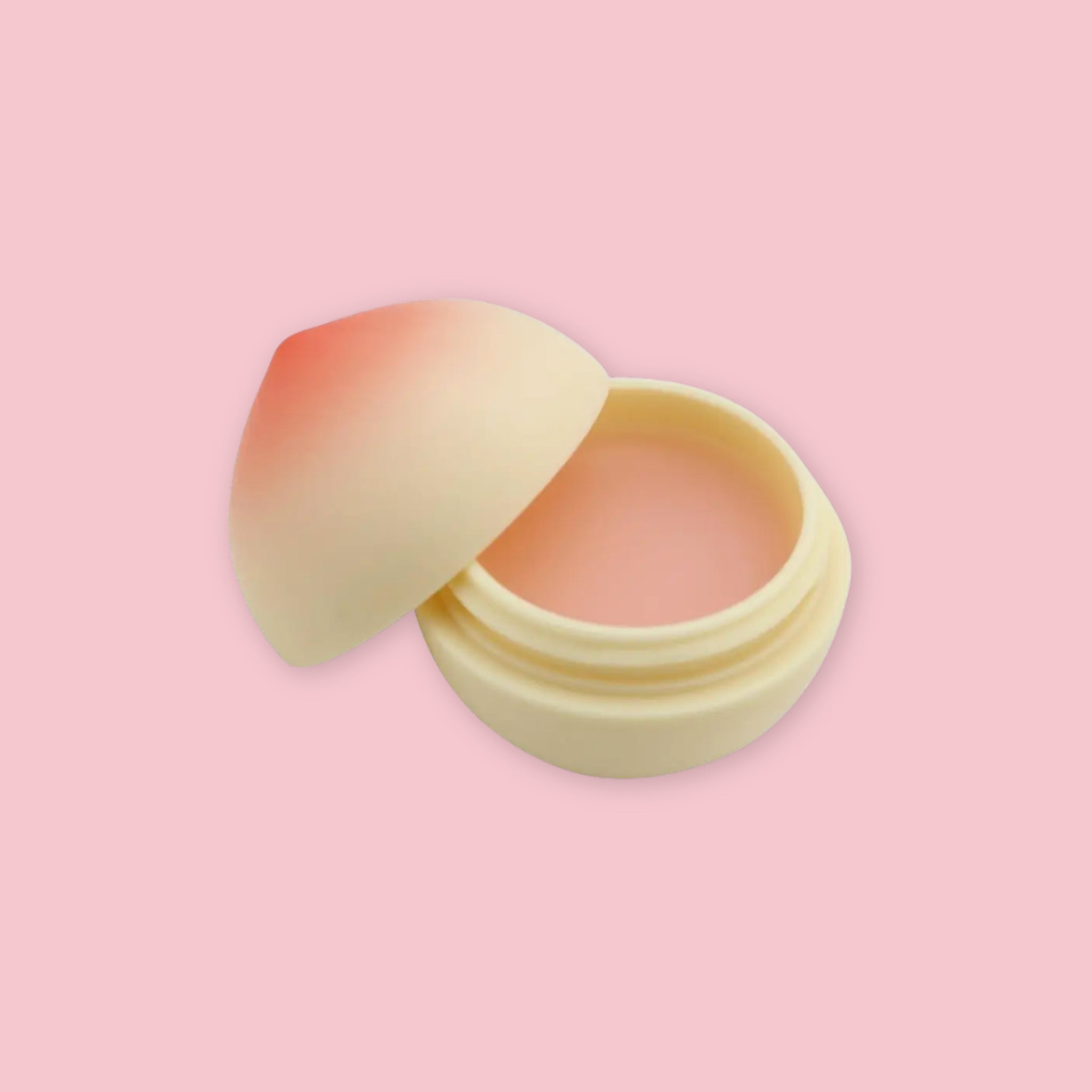 TonyMoly Peach Lip Balm in its peach-shaped container shown open, revealing the balm inside, on a pink background