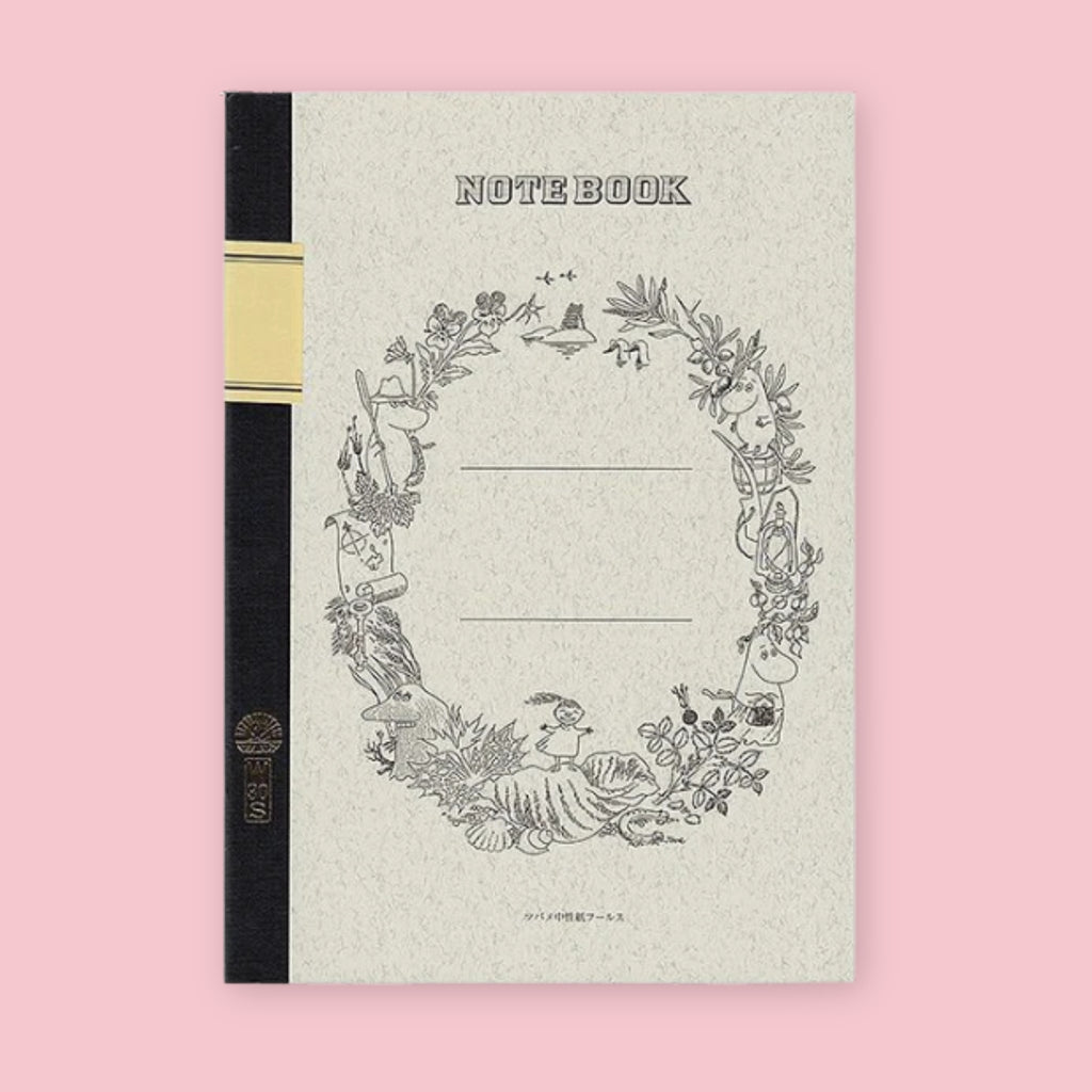 Tsubame notebook featuring Moomin illustrations, with a textured white cover, black spine, and detailed woodland wreath border surrounding blank label lines in the center. The monochrome artwork includes Moomin characters, plants, and nature scenes.