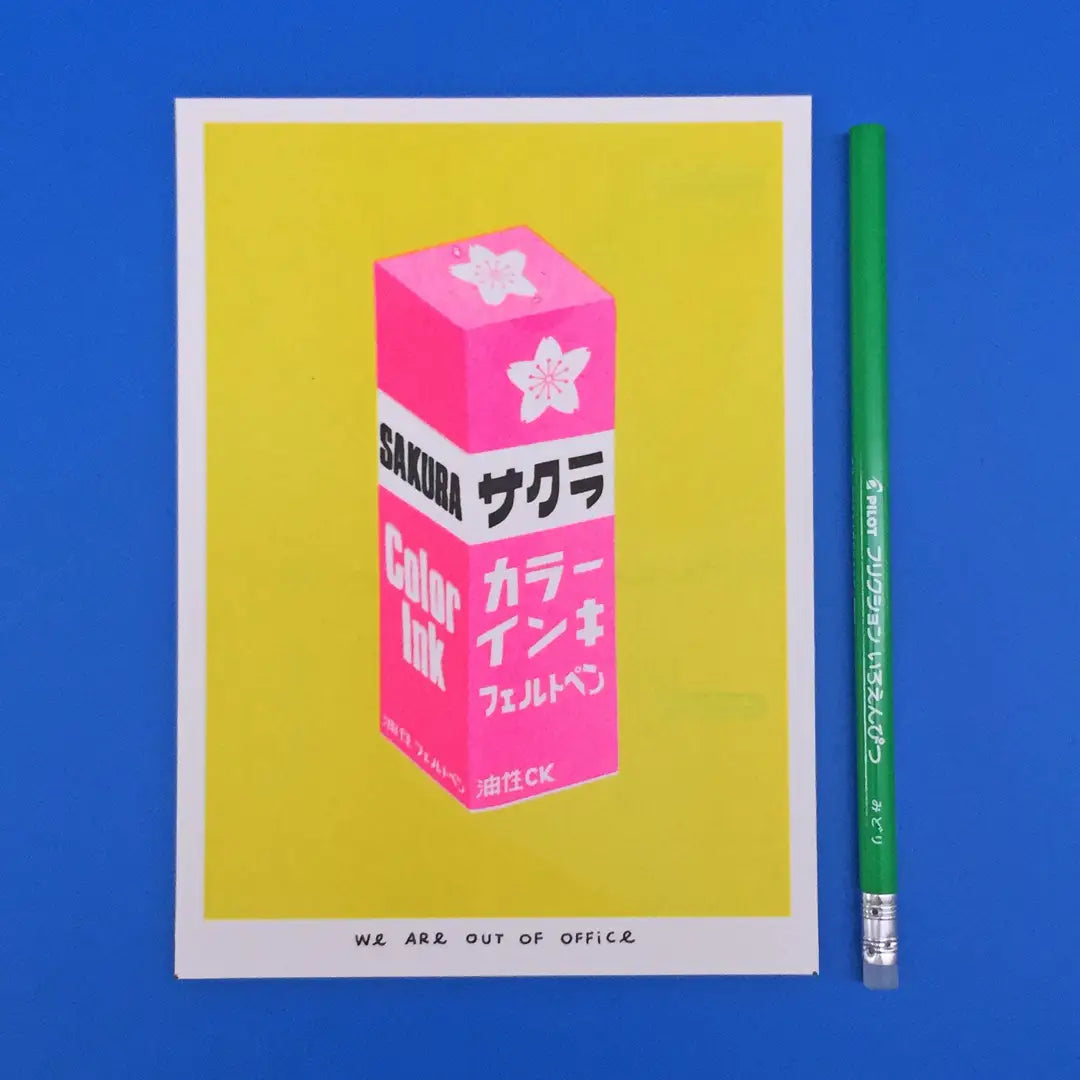 We Are Out of Office risograph art print featuring a pink Sakura color ink box illustration on a yellow background, photographed on blue with a green pencil.