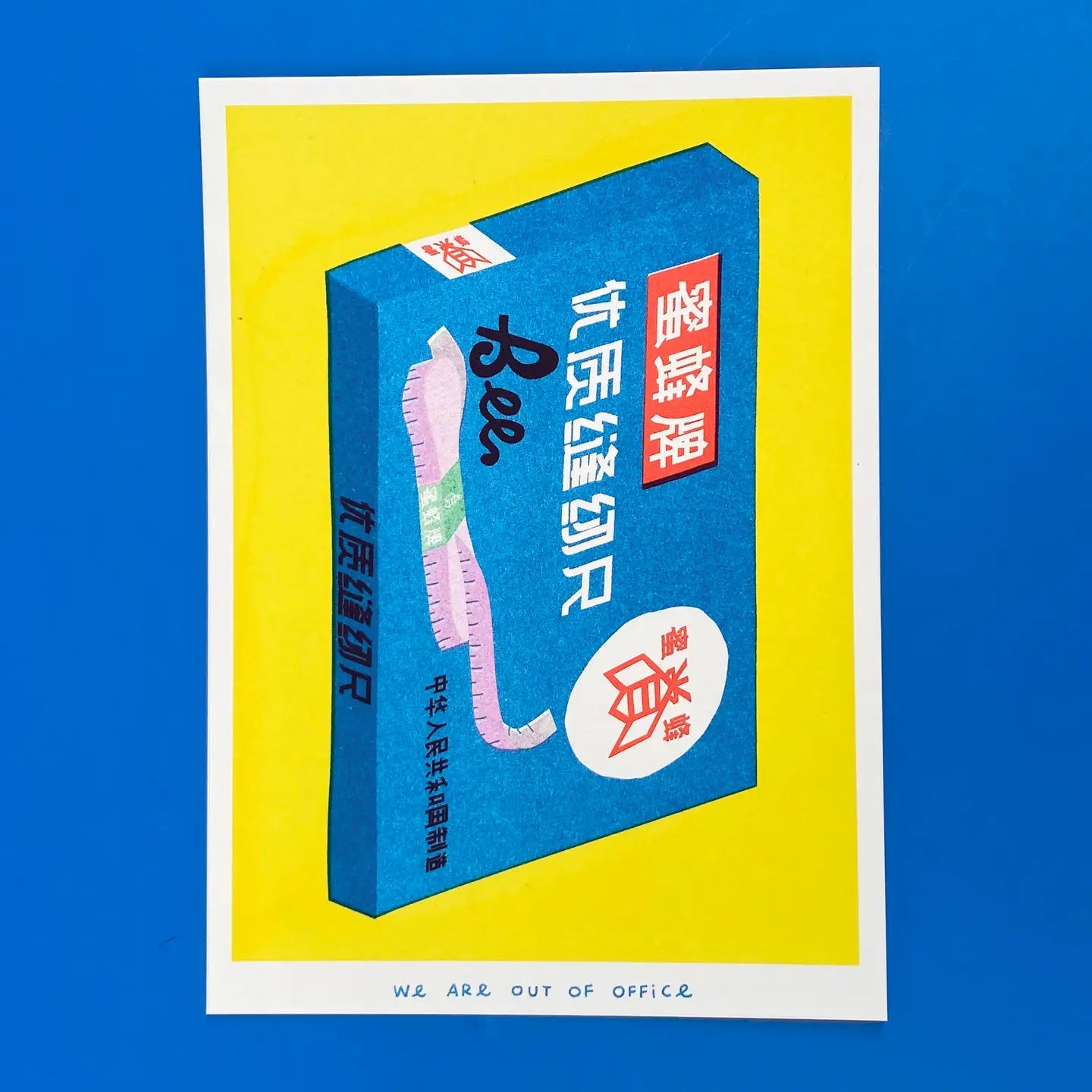 We Are Out of Office risograph art print featuring a blue Chinese measuring tape box illustration on a yellow background, photographed against blue.
