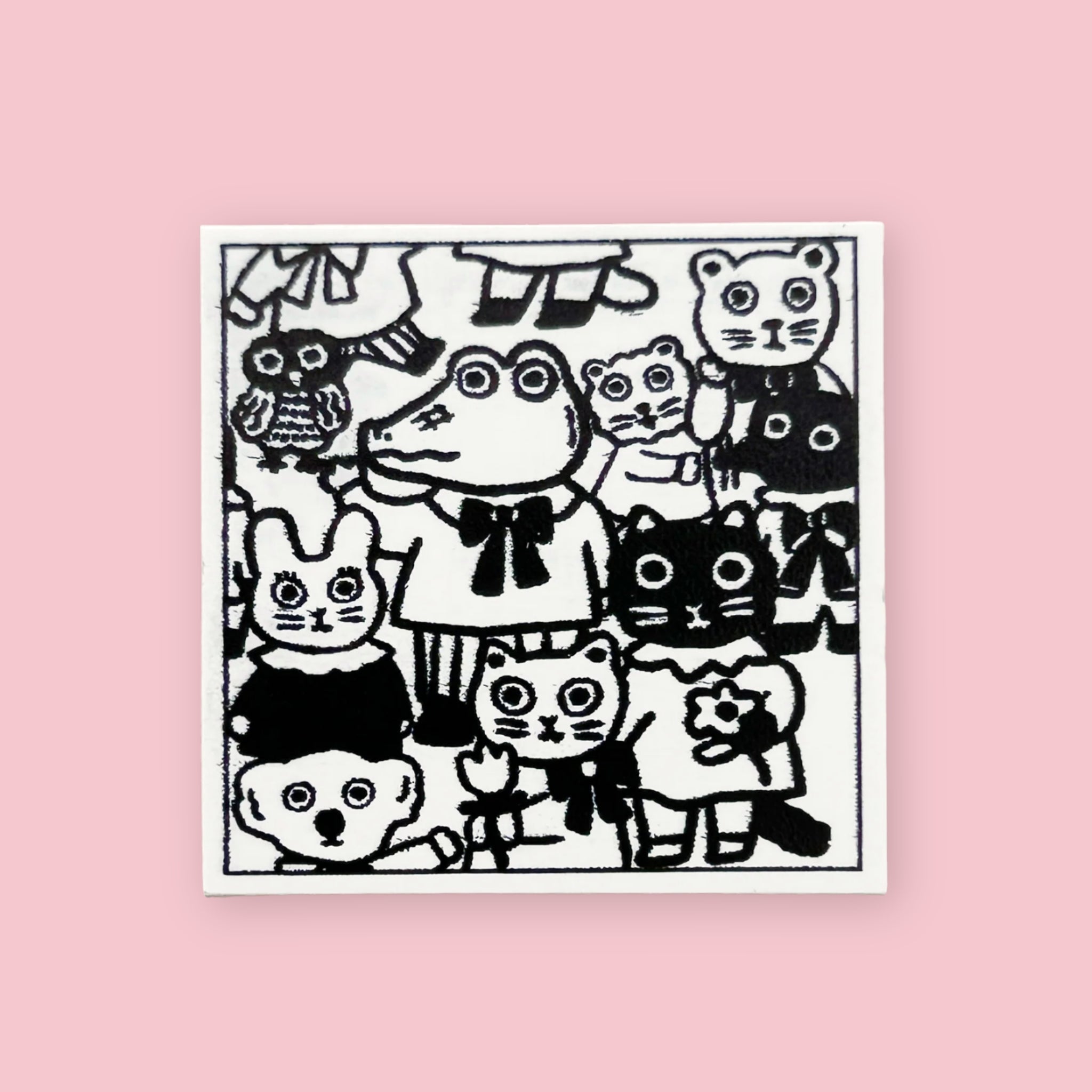 Yumi Kitagishi rubber stamp showing a crowd of wide-eyed animals including a frog, owl, bear, cats, and rabbits in various sizes and poses, printed in black ink on white paper, on a pink background.